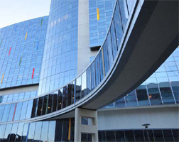 Complex glass curtain wall construction is shown.
